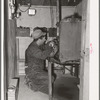 George Hutton, Jr., working on his homemade electric plant. Hutton took a correspondence course in electricity and has almost completely electrified all of his father's farm. Pie Town, New Mexico