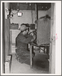 George Hutton, Jr., working on his homemade electric plant. Hutton took a correspondence course in electricity and has almost completely electrified all of his father's farm. Pie Town, New Mexico
