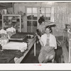 A neighbor fixes the grocery clerk's hair at Pie Town, New Mexico