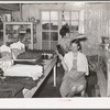 A neighbor fixes the grocery clerk's hair at Pie Town, New Mexico
