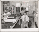 A neighbor fixes the grocery clerk's hair at Pie Town, New Mexico