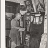 Mrs. George Hutton, homesteader, in front of her bookcase. Pie Town, New Mexico