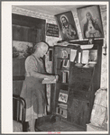 Mrs. George Hutton, homesteader, in front of her bookcase. Pie Town, New Mexico