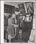 Mrs. George Hutton, homesteader, in front of her bookcase. Pie Town, New Mexico
