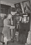 Mrs. George Hutton, homesteader, in front of her bookcase. Pie Town, New Mexico