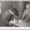 Mrs. George Hutton and her son measure off paper for the kitchen. Pie Town, New Mexico