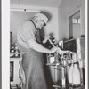 Member of the Casa Grande Valley Farms, Arizona, capping milk bottles