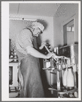 Member of the Casa Grande Valley Farms, Arizona, capping milk bottles