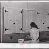 Wife of member of the Casa Grande Farms working at her kitchen sink. Pinal County, Arizona
