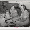Children dropping their collection nickles on the open Bible at the Sunday school at the community house of the Casa Grande Valley Farms. Pinal County, Arizona