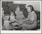 Children dropping their collection nickles on the open Bible at the Sunday school at the community house of the Casa Grande Valley Farms. Pinal County, Arizona