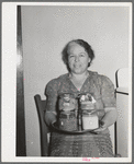 Wife of member of the Casa Grande Valley Farms, displaying canned goods with which she won prizes at the state fair. Pinal County, Arizona