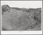 Sacramento Pit copper mine at Bisbee, Arizona. This is a pit 435 feet deep. In 1911 a shaft was sunk into the slopes of the east wall. In 1917 a dynamite charge blew off the top rock of the crown and dredges were worked to excavate the pit's ore bodies