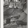 Eugene Davis, gold prospector, making a pot of coffee in his shack on his diggings. Pinos Altos, New Mexico