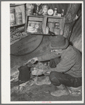 Eugene Davis, gold prospector, making a pot of coffee in his shack on his diggings. Pinos Altos, New Mexico