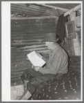 Eugene Davis, gold prospector, reading over location notice form which must be filed along with mining claim. Pinos Altos, New Mexico