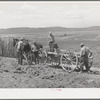 Members of FSA cooperative manure spreader placing manure on farmland. Box Elder County, Utah