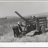 Unloading FSA cooperative ditcher from trailer. Box Elder County, Utah