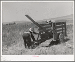 Unloading FSA cooperative ditcher from trailer. Box Elder County, Utah