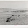 Ericson brothers' cooperative tractor, bought with FSA loan, plowing dry land. Irrigated land is seen in the middleground of the picture. Box Elder County, Utah