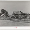 Houses belonging to a Mormon farmer in Mendon, Utah. The new house was built with profits from his farm