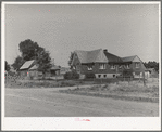 Houses belonging to a Mormon farmer in Mendon, Utah. The new house was built with profits from his farm