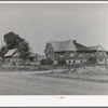 Houses belonging to a Mormon farmer in Mendon, Utah. The new house was built with profits from his farm