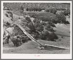 Irrigation water crossing ditch in hollowed out log. Trampas, New Mexico