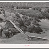 Irrigation water crossing ditch in hollowed out log. Trampas, New Mexico