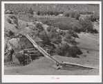 Irrigation water crossing ditch in hollowed out log. Trampas, New Mexico