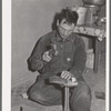 Spanish-American farmer repairing his wife's shoes. Chamisal, New Mexico