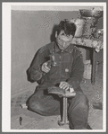 Spanish-American farmer repairing his wife's shoes. Chamisal, New Mexico