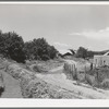 Irrigation ditch flows across road at entrance to Chamisal, New Mexico