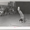 Spanish-American acrobat of traveling show. Audience in background. Penasco, New Mexico