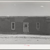 Front of Spanish-American house, Penasco, New Mexico. Notice the small windows, however; because of the brilliant suns in this section, the interiors of the houses are not dark and drab, rather the light seems pleasant and subdued