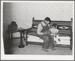 Spanish-American farmer and his daughter seated on couch which his son made at school workshop in Albuquerque. Chamisal, New Mexico