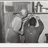 Mrs. Hutton and her son papering the kitchen. Pie Town, New Mexico