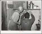 Mrs. Hutton and her son papering the kitchen. Pie Town, New Mexico