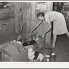 Mrs. Faro Caudill packing up kitchen equipment for moving to new dugout nearer the well. Notice the pressure cooker. These homesteaders say that the pressure cooker should be put on the national flag for they think it's saving the farm folks for America