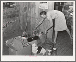 Mrs. Faro Caudill packing up kitchen equipment for moving to new dugout nearer the well. Notice the pressure cooker. These homesteaders say that the pressure cooker should be put on the national flag for they think it's saving the farm folks for America