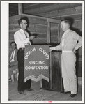 President of the singing convention. He is also a homesteader, on the right presenting the banner to Mr. Whinery as representative of one group of the contesting singers. Pie Town, New Mexico