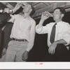 The men have a bottle of beer at the square dance. Pie Town, New Mexico