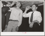 The men have a bottle of beer at the square dance. Pie Town, New Mexico