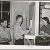 Young miner cashing check at commissary while another waits in line for his turn. Mogollon, New Mexico