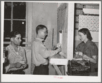 Young miner cashing check at commissary while another waits in line for his turn. Mogollon, New Mexico