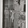 Workman checking miners' lights. Batteries of these lights are checked every day. Mogollon, New Mexico