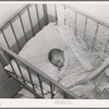 Spanish-American baby in its crib. Chamisal, New Mexico