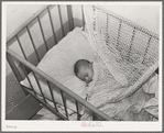 Spanish-American baby in its crib. Chamisal, New Mexico