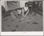 Children of Mormon farmer playing marbles in the living room. Santa Clara, Utah