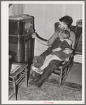 John Frost and daughter listening to radio in their home. Tehama County, California